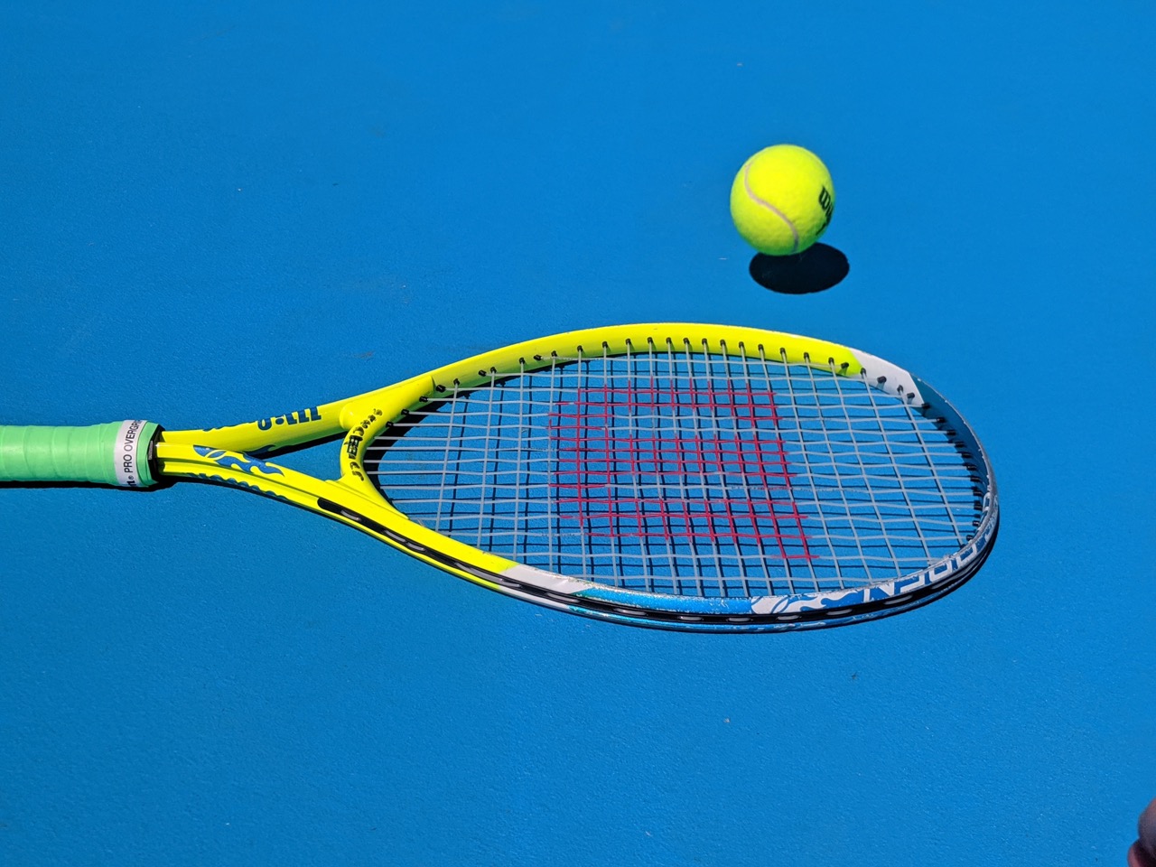 Raquette sur un terrain de tennis avec une balle